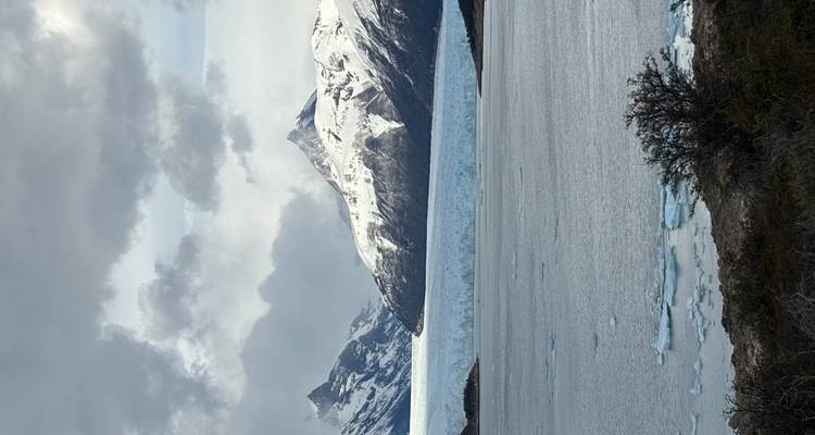 Besneeuwde berg en gletsjer bij een meer.