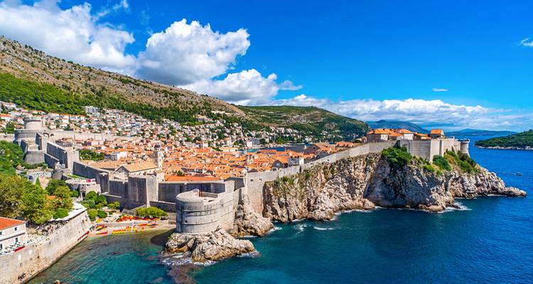 Panoramisch kustgezicht van Dubrovniks ommuurde Oude Stad gelegen op kliffen boven de azuurblauwe Adriatische Zee.