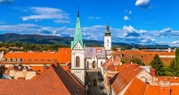 Dakterrassenpanorama van Zagreb met de St. Markuskerk met zijn kleurrijke tegeldak en omringende torenspitsen.