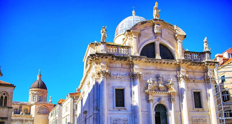 Baroque Church of St. Blaise in Dubrovnik gleams under a vibrant blue sky.