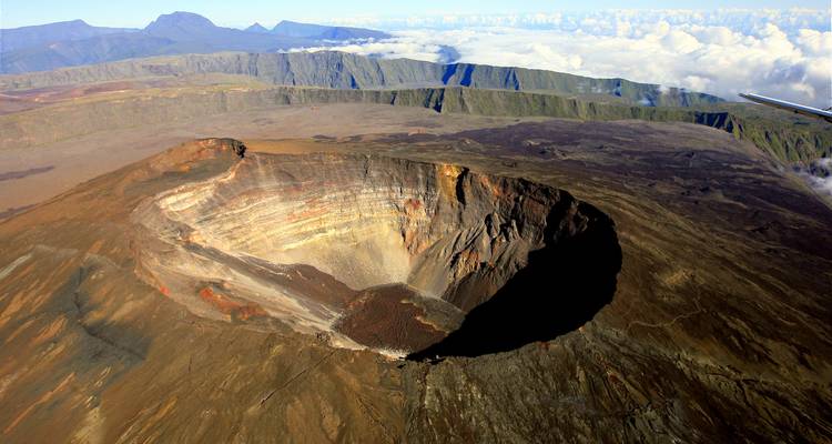Un gran cráter volcánico visto desde arriba con formaciones rocosas en capas.