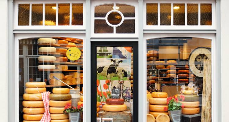 Shopfront filled with various kinds of cheese.
