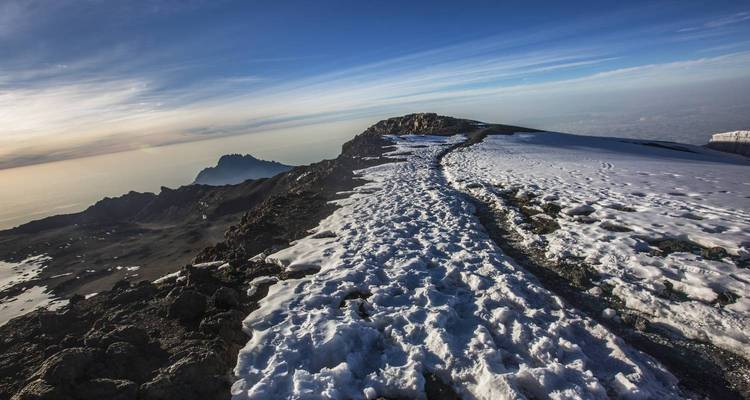 Schneebedeckter Gipfel des Kilimandscharo mit dramatischem Morgenlicht.