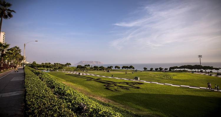 Green coastal park in Miraflores overlooking the Pacific with walking paths and distant Isla San Lorenzo.