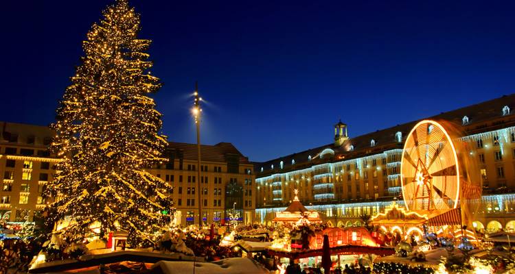 Marché nocturne d'hiver illuminé de lumières festives et d'un grand sapin de Noël.
