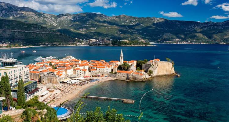 Panoramische Luftaufnahme der Altstadt von Budva mit Terrakottadächern, Zitadelle und türkisfarbenem Adriatischen Meer.