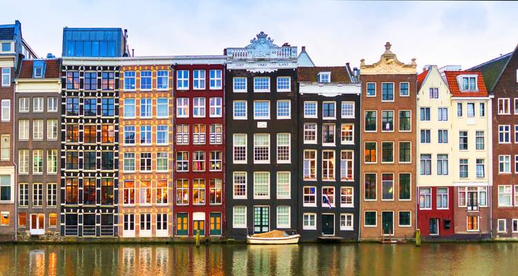 Canal houses in Amsterdam reflecting in the water.