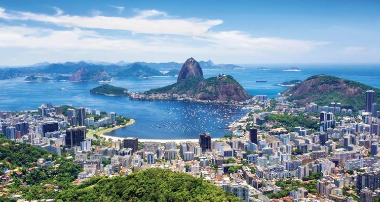 Iconic aerial panorama of Rio de Janeiro with Sugarloaf Mountain, Guanabara Bay and the city skyline under a clear sky.