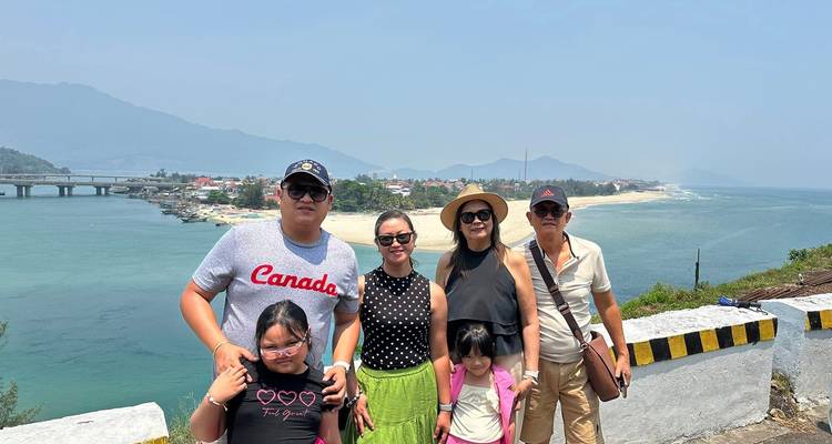 Famille posant avec une rivière et un pont en arrière-plan.