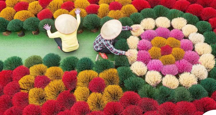 Deux femmes arrangeant des bâtons d'encens colorés.