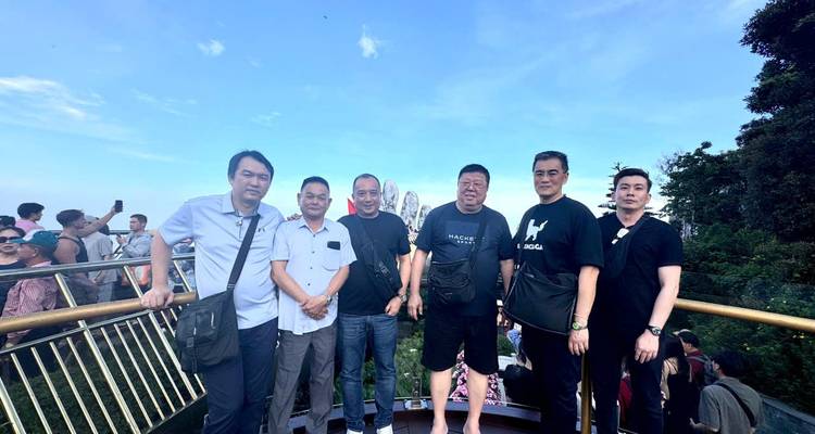 Groep van zes mensen op brug met schilderachtig uitzicht.