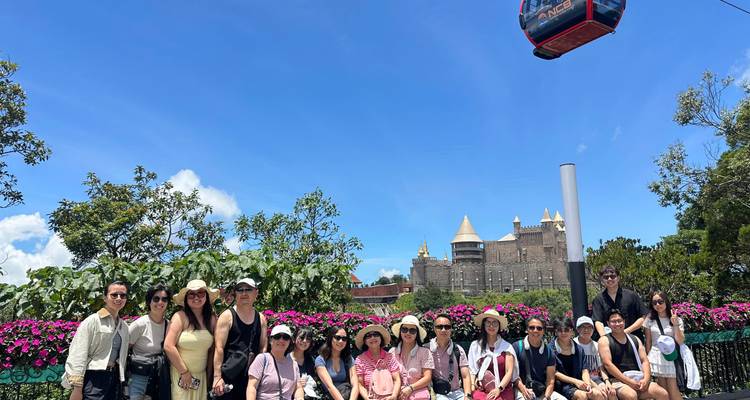 Groupe de touristes devant une structure semblable à un château dans les collines de Bana.