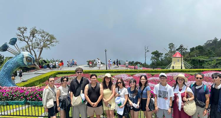 Photo de groupe dans un espace jardin avec des fleurs colorées.