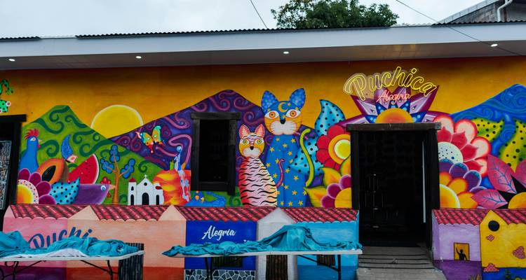 Fresque colorée sur un mur représentant des animaux stylisés et des motifs.