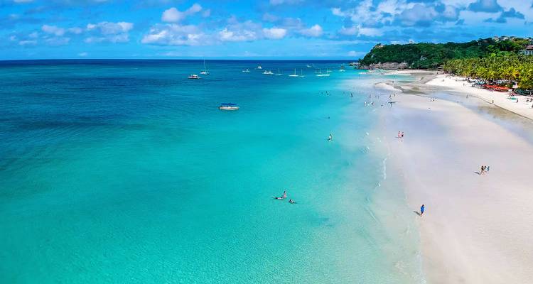 Une vue aérienne panoramique de la célèbre plage de sable blanc de Boracay avec une eau turquoise cristalline s'étendant jusqu'à l'horizon.