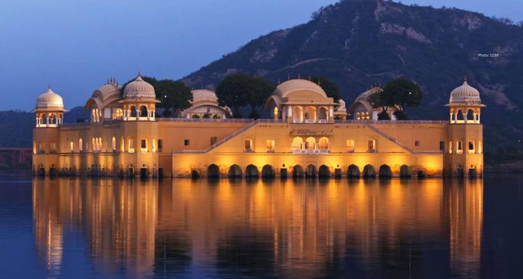 The illuminated Jal Mahal palace floating on a lake at night.