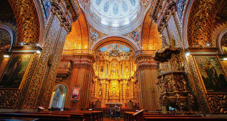Het weelderig vergulde interieur van Quito's sierlijke barokke kerk straalt onder een gewelfde plafond.