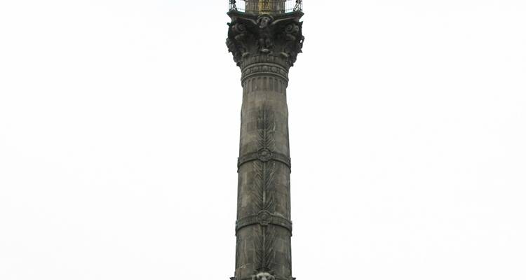 Colonne de l'Ange de l'Indépendance isolée sur un fond de ciel blanc.