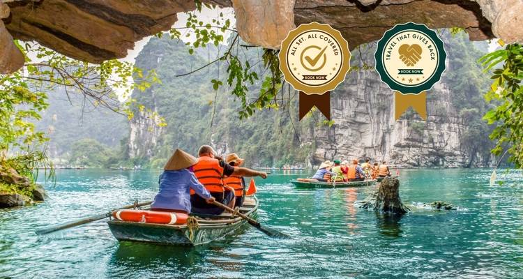 Tourists in boats on turquoise water with limestone mountains.