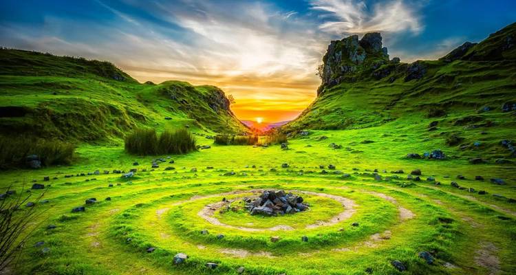 Fairy Glen with spiral rocks and green hills during sunset.