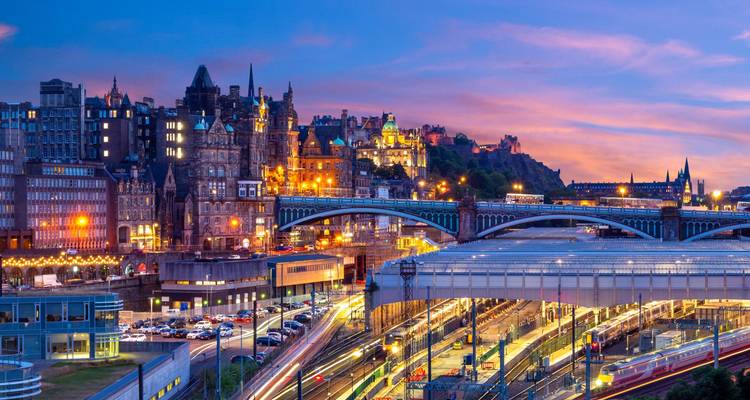 Edinburgh at dusk with light trails, bridges, and city architecture.