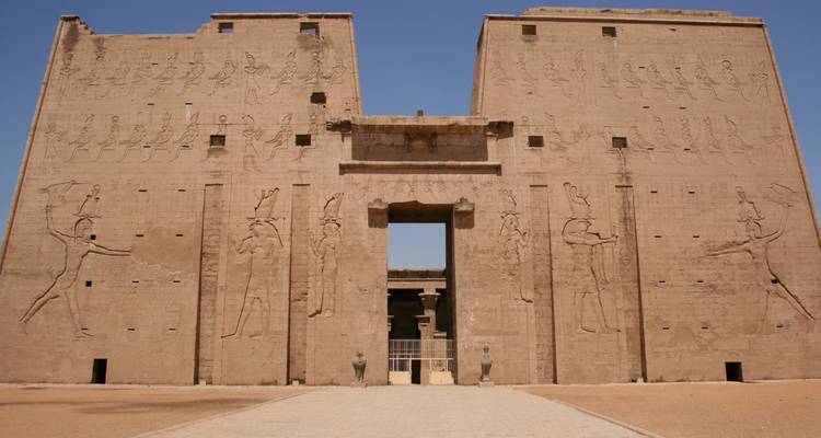 Massive sandstone gateway of Edfu Temple with carved reliefs under clear sky

Portail massif en grès du Temple d'Edfou avec des reliefs sculptés sous un ciel dégagé