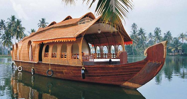 Hausboot schwimmend auf Brackwasser zwischen Palmen.