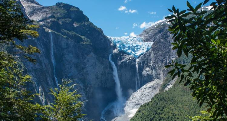 Impresionante glaciar colgante que cae en cascada hacia un valle con una alta cascada en el Parque Nacional Queulat