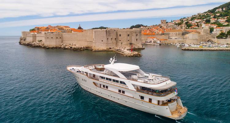 Yate lujoso cerca de una muralla de fortaleza antigua.