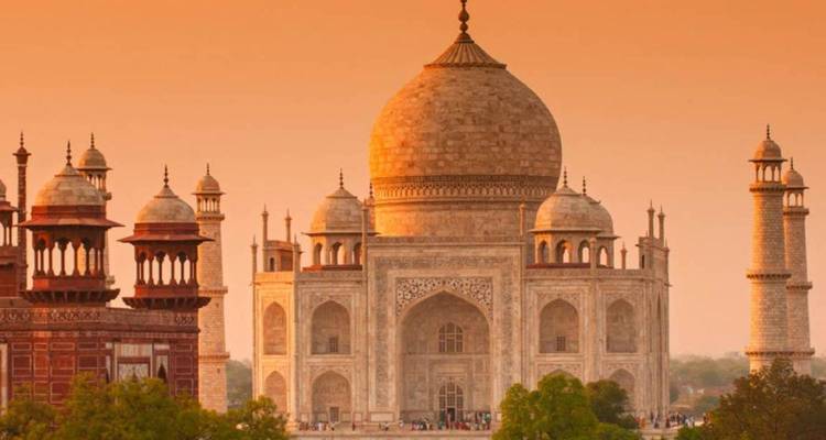 Het beroemde witte marmeren mausoleum met vier minaretten, gloeiend onder een zonsondergang.