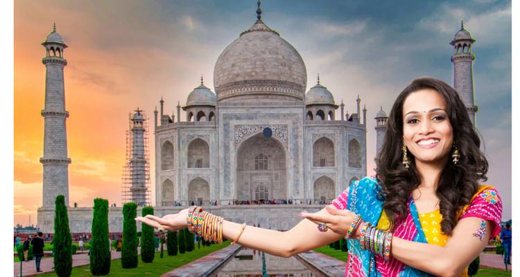 Frau in farbenfrohem Sari deutet bei Sonnenuntergang auf das Taj Mahal in einer Composit-Stilisierung.