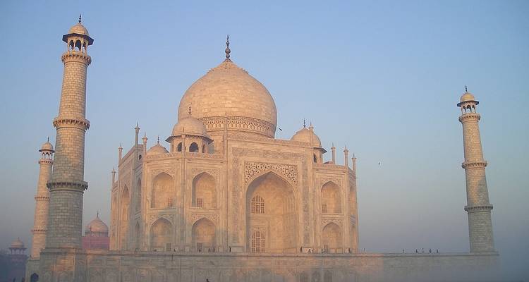 Le Taj Mahal au lever du soleil avec un premier plan brumeux.