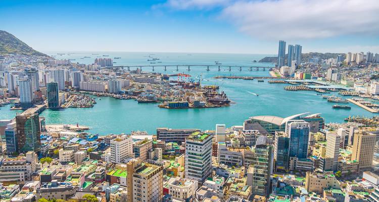 Luftaufnahme einer Küstenstadt mit einer markanten Brücke und Gebäuden.