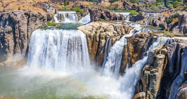 Large cascading waterfalls with mist and a rainbow.