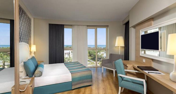 Modernes Hotelzimmer mit Meerblick durch große Fenster.