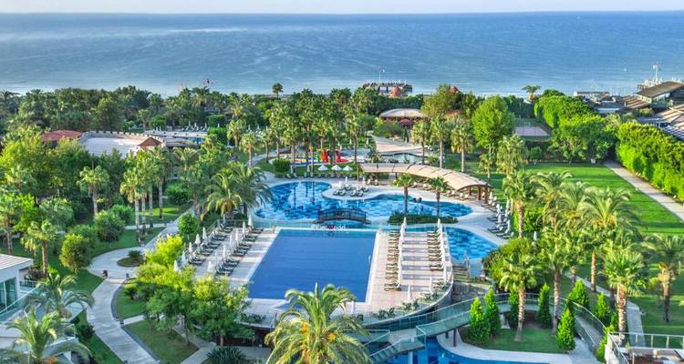 Ein üppiges Ferienresort mit einem großen Pool mit Meerblick.