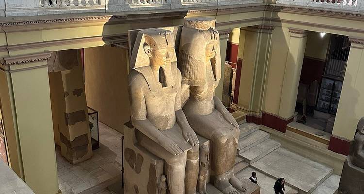Deux grandes statues égyptiennes antiques à l'intérieur d'un musée ou d'un temple.