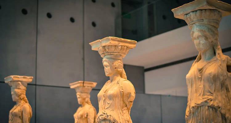 Rij van antieke Kariatide standbeelden tentoongesteld in een moderne museumomgeving