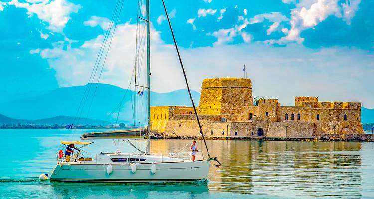 Zeilboot varend nabij zeevesting Bourtzi bij Nafplio op kalm turquoise water