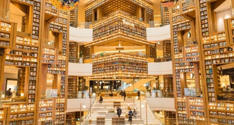 Moderne Bibliothek mit ausgedehnten Bücherregalen und Treppen.
