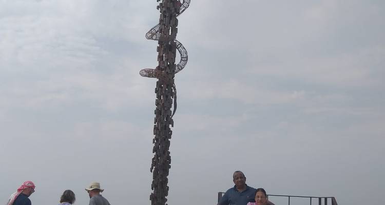 Un groupe de personnes près d'une grande sculpture.