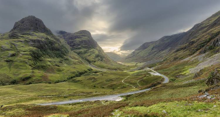 Dramatic landscape of a mountainous valley under a cloudy sky.