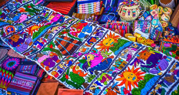 Des textiles tissés aux couleurs éclatantes et des objets d'artisanat exposés dans un étal de marché traditionnel