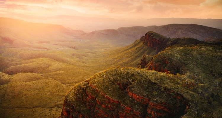 Malerische Aussicht auf einen Sonnenuntergang über einer Bergkette und einem Tal.