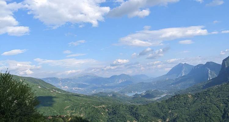 Vast mountain range under a sky with scattered clouds.