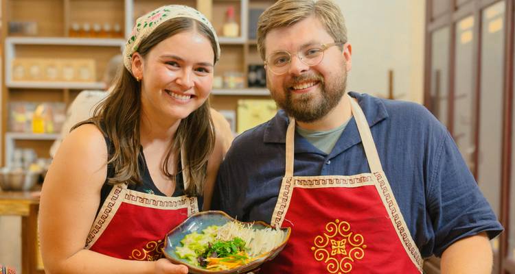 Un couple posant avec un plat qu'ils ont préparé dans un cours de cuisine.