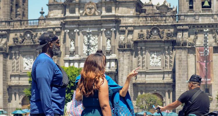 Visitantes tomando fotos frente a un edificio histórico.
