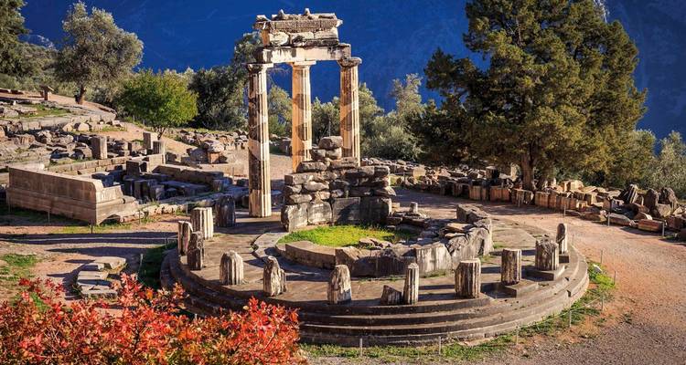 Ancient ruins at a historical site surrounded by trees.