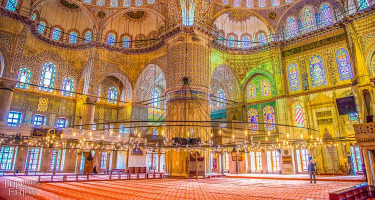 Farbenfrohe Innenausstattung der Blauen Moschee mit gemusterten Fliesen und hängenden Leuchten