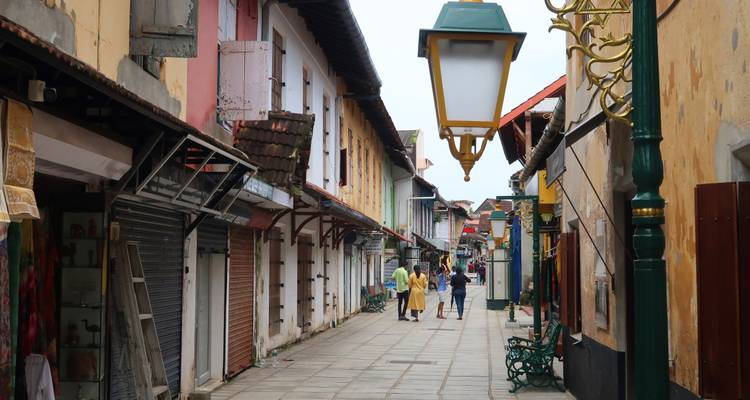 Calle estrecha e histórica en Fort Kochi llena de coloridos edificios coloniales y tiendas.